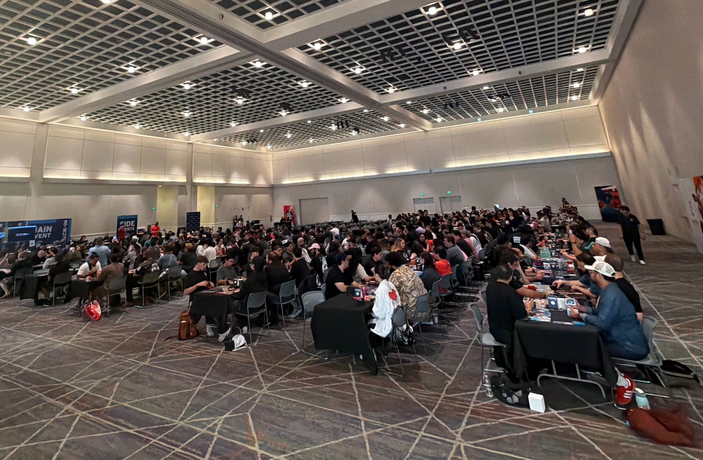 A crowded Azuki TCG tournament in a large convention hall.