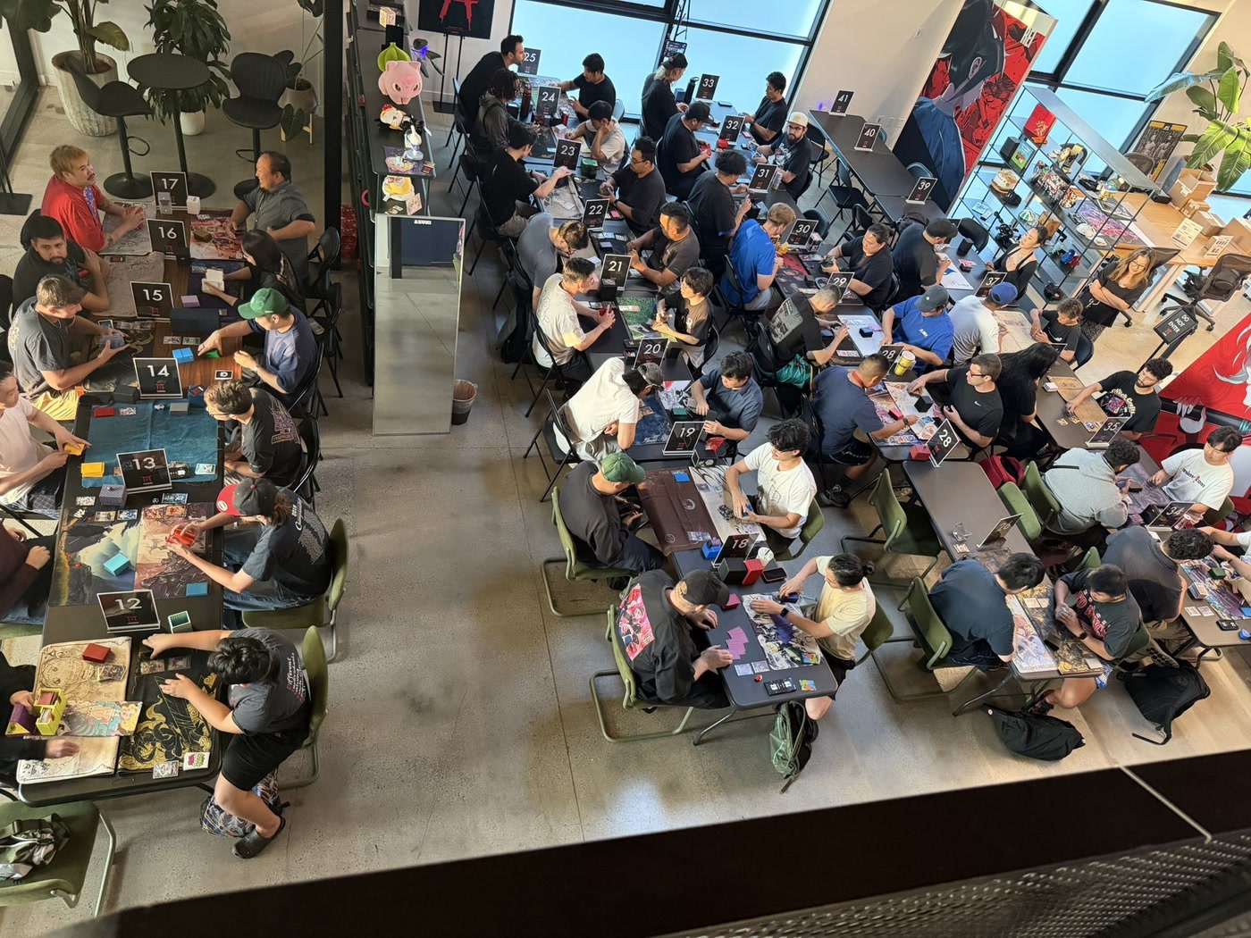 Azuki TCG players competing across numbered tournament tables.