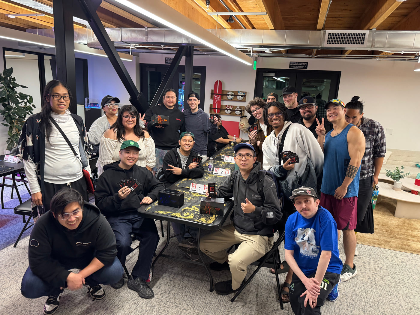 Azuki TCG players posing together around a card game table.